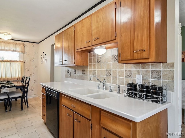 kitchen with brown cabinetry, dishwasher, a sink, baseboards, and light countertops