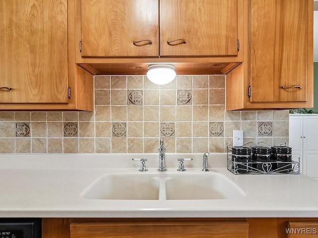 kitchen featuring a sink, decorative backsplash, brown cabinets, and light countertops