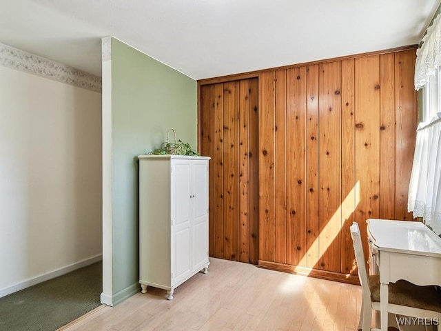 additional living space featuring light wood-type flooring and baseboards