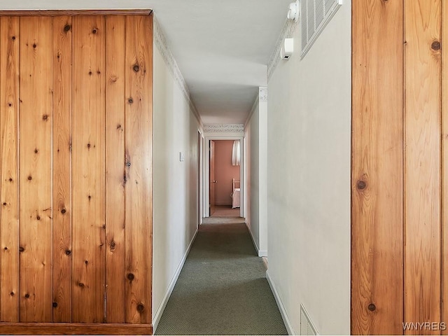 corridor featuring baseboards, carpet flooring, and visible vents