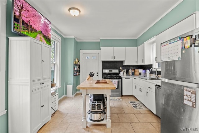 kitchen featuring a sink, white cabinetry, decorative backsplash, and stainless steel appliances