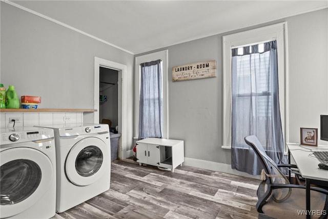 laundry area with laundry area, washing machine and clothes dryer, wood finished floors, baseboards, and ornamental molding