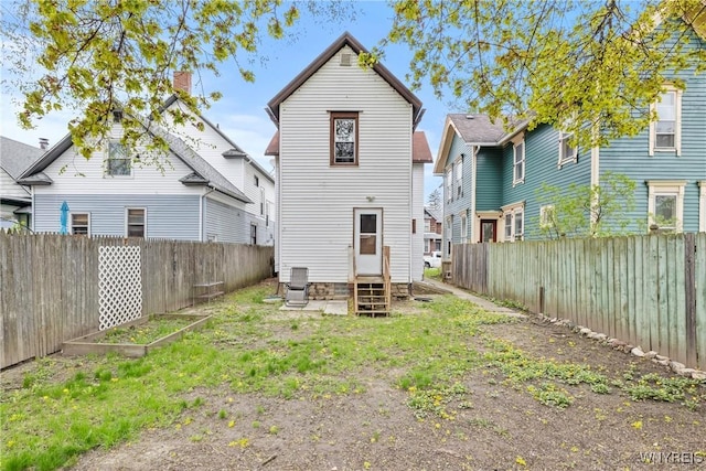 back of property featuring entry steps and a fenced backyard