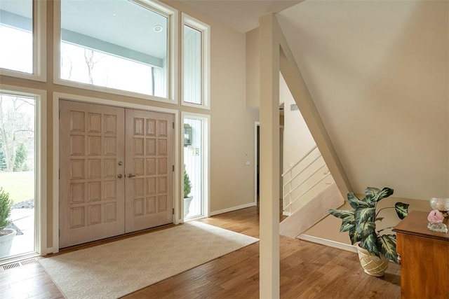 foyer entrance featuring wood finished floors, a wealth of natural light, and stairway