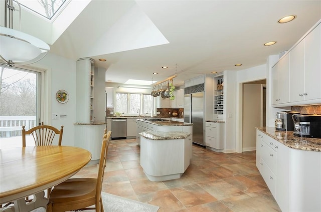 kitchen featuring recessed lighting, decorative backsplash, appliances with stainless steel finishes, and a center island