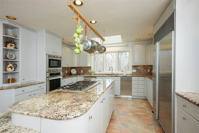 kitchen with open shelves, built in appliances, a center island, recessed lighting, and decorative backsplash