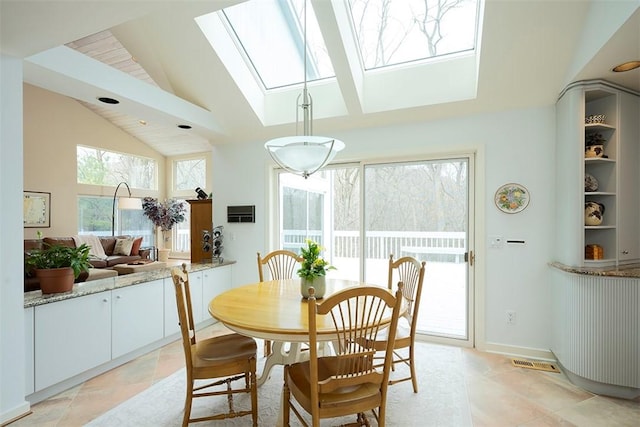 dining room with vaulted ceiling with skylight and visible vents