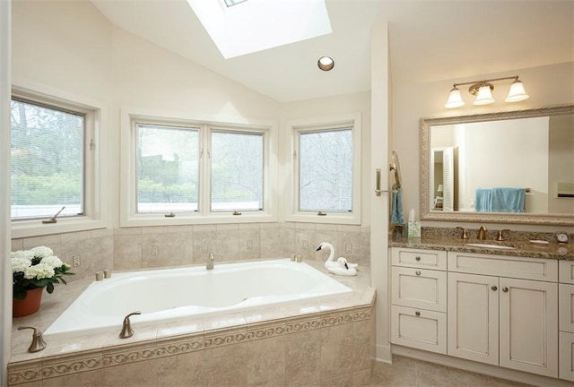 bathroom featuring plenty of natural light, a bath, vaulted ceiling with skylight, and vanity
