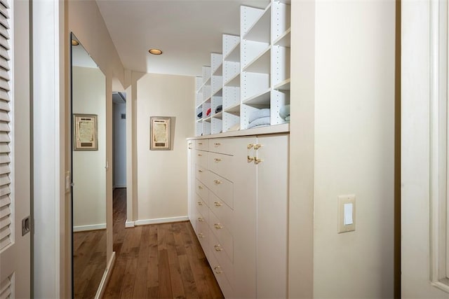 hallway featuring baseboards and dark wood-style flooring