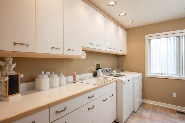 laundry room with visible vents, baseboards, separate washer and dryer, a sink, and cabinet space