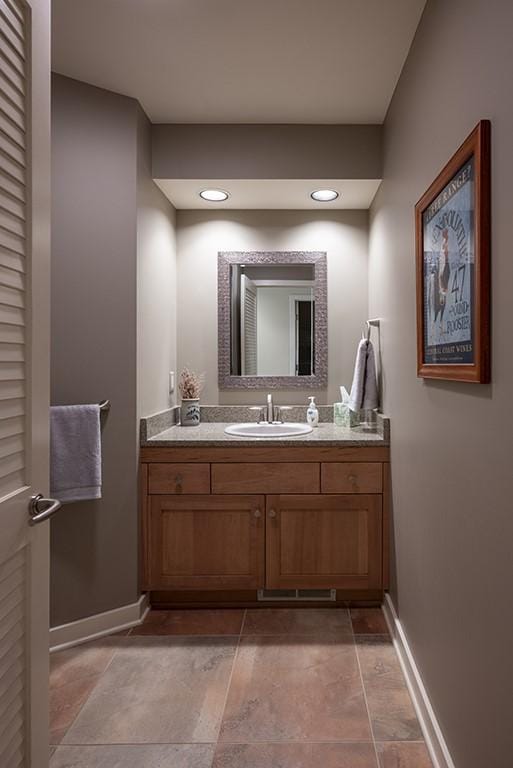 bathroom featuring baseboards, vanity, and recessed lighting