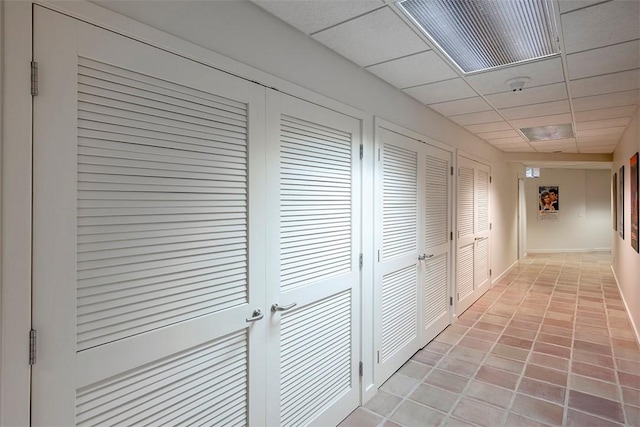 hallway with a paneled ceiling and visible vents
