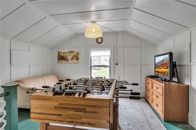 rec room featuring lofted ceiling and a decorative wall