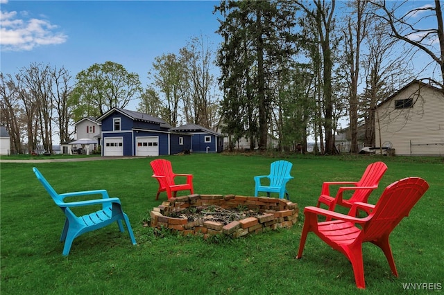 view of yard with a garage and an outdoor fire pit