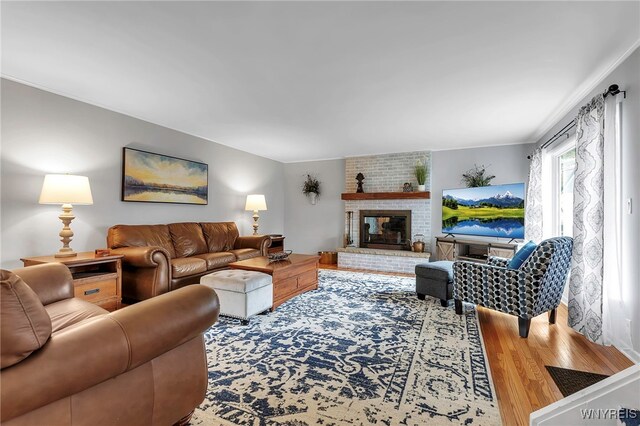 living area featuring a brick fireplace and wood finished floors
