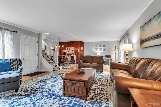living area featuring stairs, wood finished floors, and wooden walls