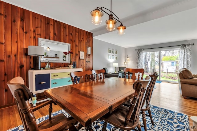 dining room with wood walls and wood finished floors
