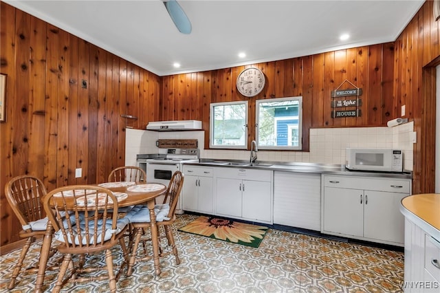 kitchen with recessed lighting, stainless steel counters, decorative backsplash, and white appliances