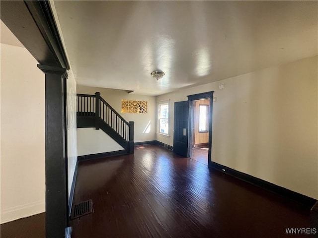 foyer entrance with stairs, baseboards, visible vents, and wood finished floors