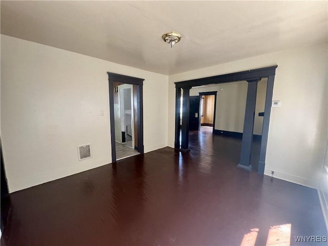 empty room featuring baseboards and visible vents