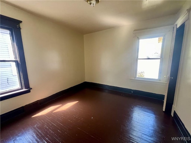 unfurnished room with baseboards and hardwood / wood-style flooring