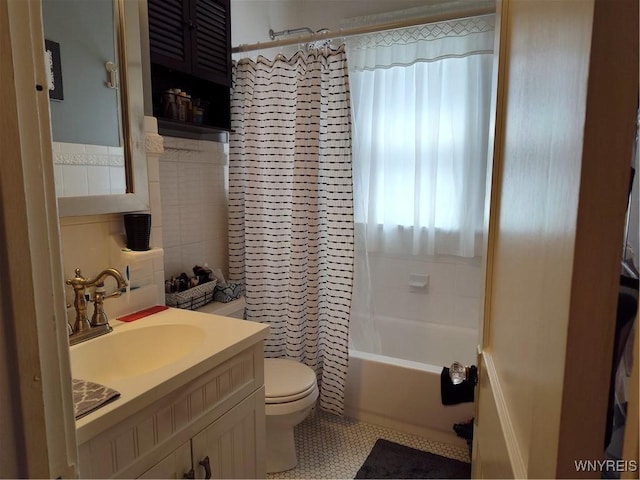 bathroom with tile patterned flooring, vanity, toilet, tile walls, and shower / tub combo