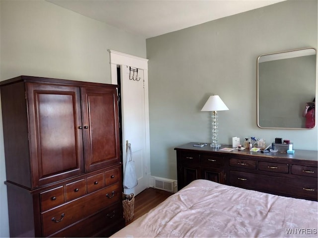 bedroom featuring visible vents, baseboards, and wood finished floors