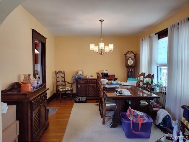 dining space featuring wood finished floors and a notable chandelier