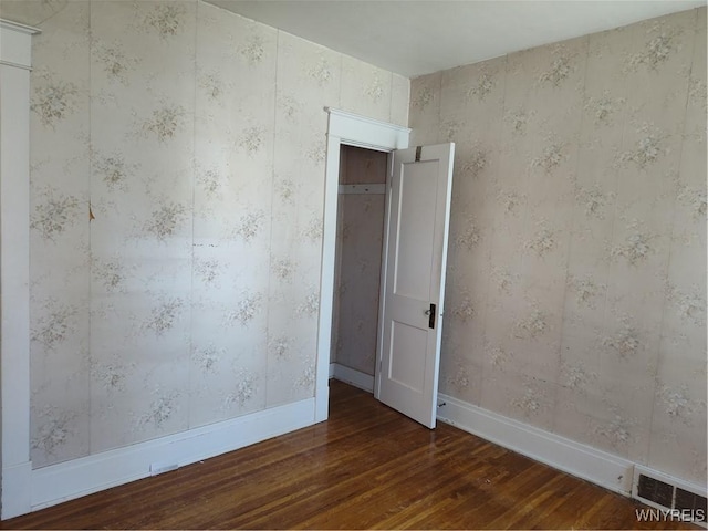 spare room featuring visible vents, baseboards, and hardwood / wood-style flooring