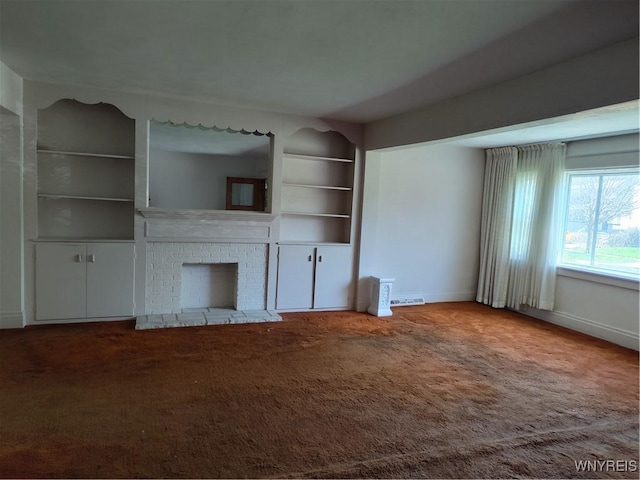 unfurnished living room with visible vents, a brick fireplace, built in shelves, baseboards, and carpet flooring
