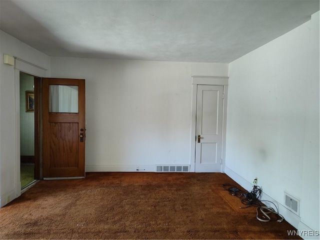 carpeted empty room featuring baseboards and visible vents