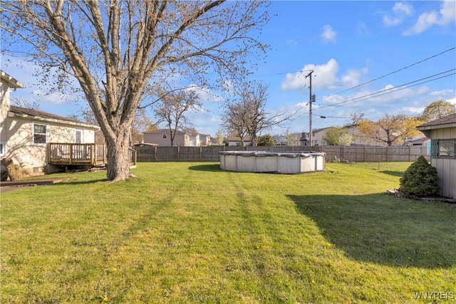 view of yard with a fenced in pool, a fenced backyard, and a wooden deck