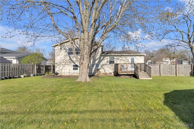 rear view of property featuring a lawn, a fenced backyard, a chimney, and a deck