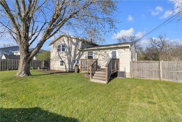 back of house with a yard, a wooden deck, and a fenced backyard