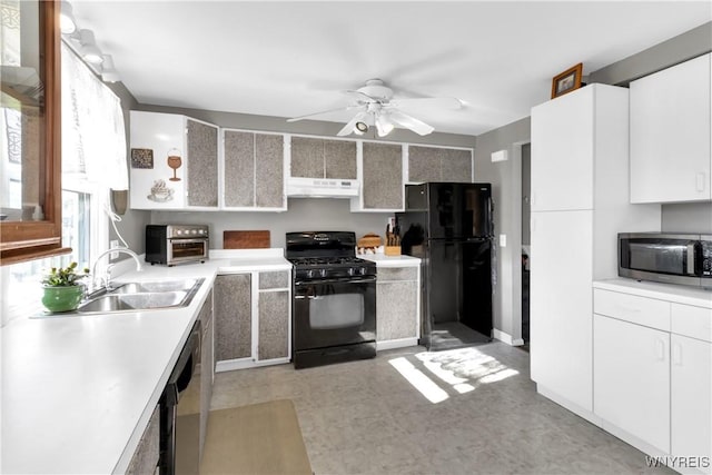 kitchen featuring ceiling fan, a sink, light countertops, black appliances, and under cabinet range hood