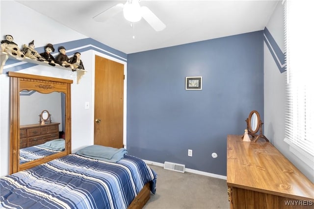 carpeted bedroom featuring visible vents, baseboards, and ceiling fan