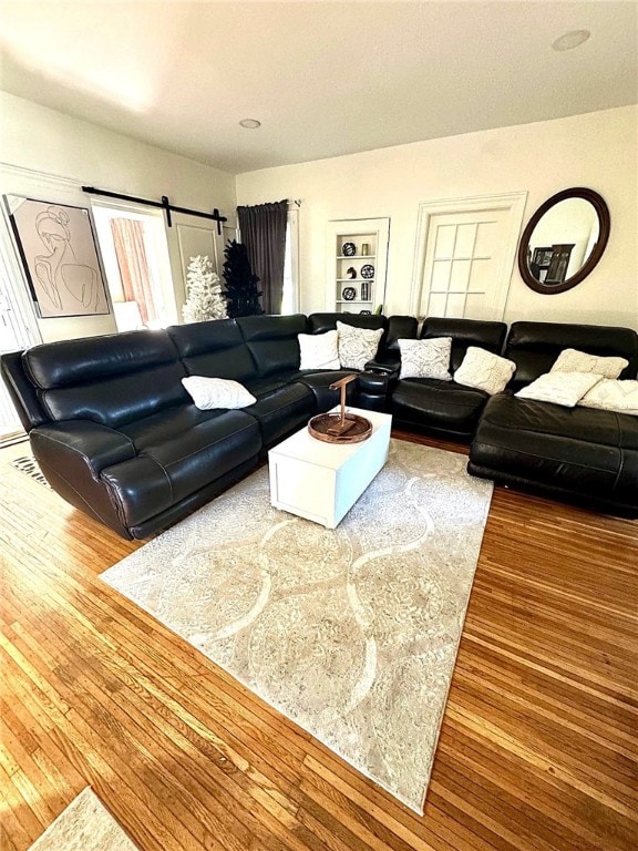 living room with built in features and wood finished floors