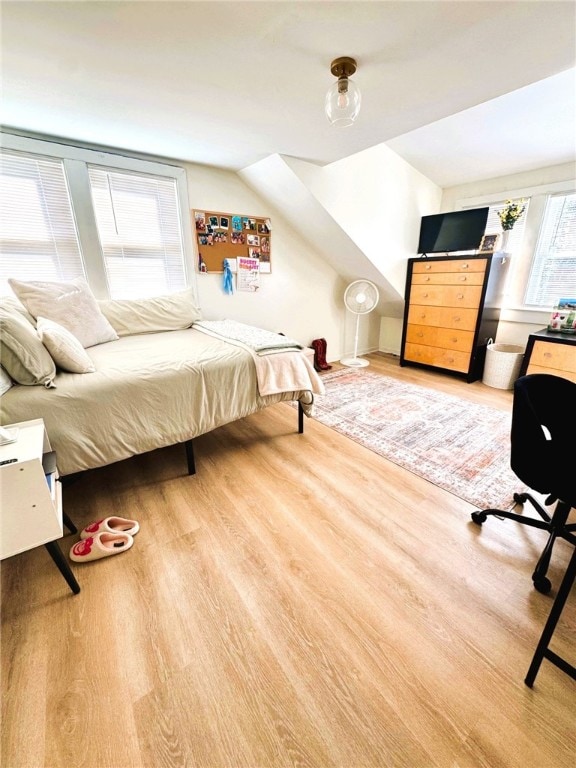 bedroom with wood finished floors and vaulted ceiling