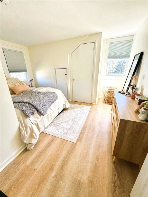 bedroom featuring light wood-style floors and baseboards