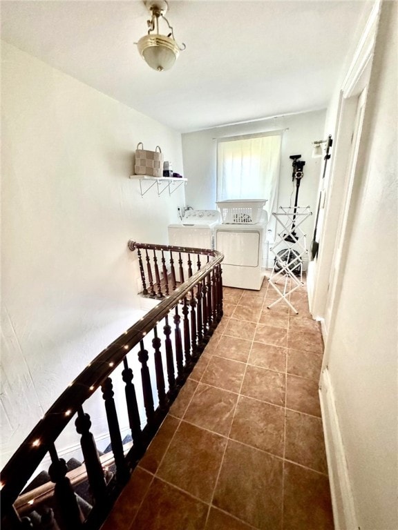 corridor with separate washer and dryer and tile patterned floors