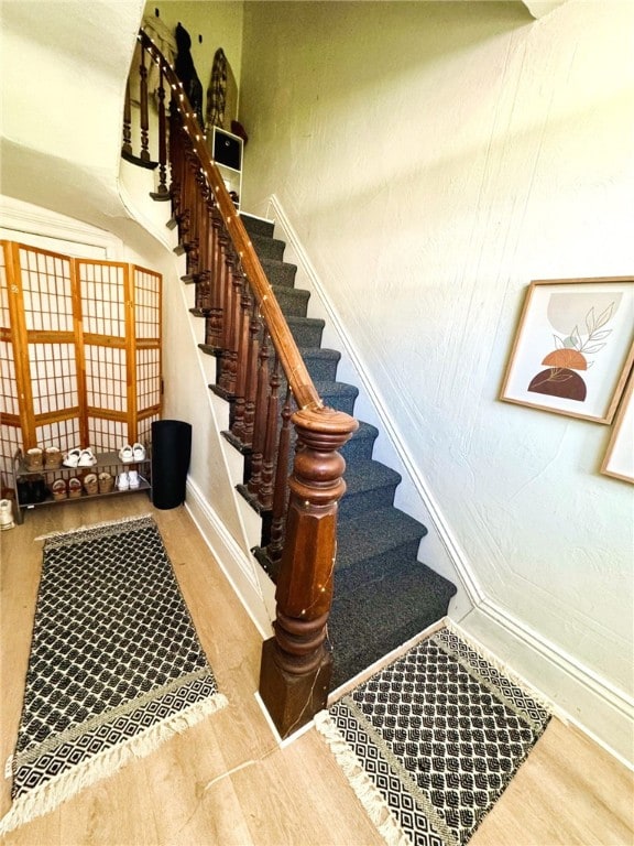 stairway featuring baseboards and wood finished floors