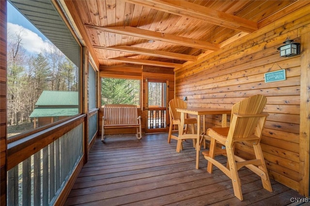 sunroom / solarium featuring beam ceiling