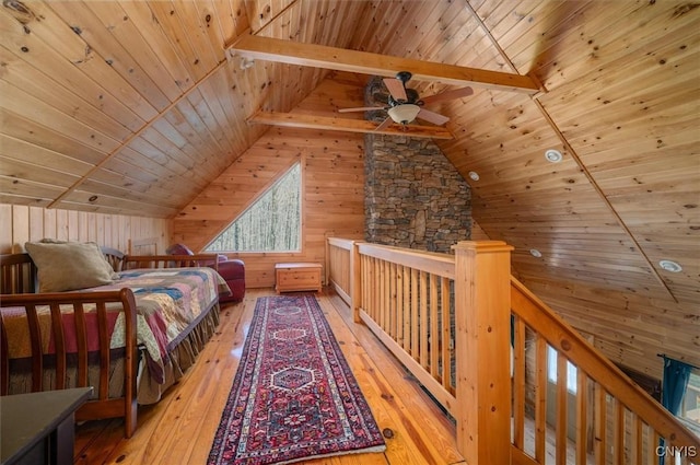 bedroom with light wood-style floors, wooden ceiling, lofted ceiling with beams, and wood walls