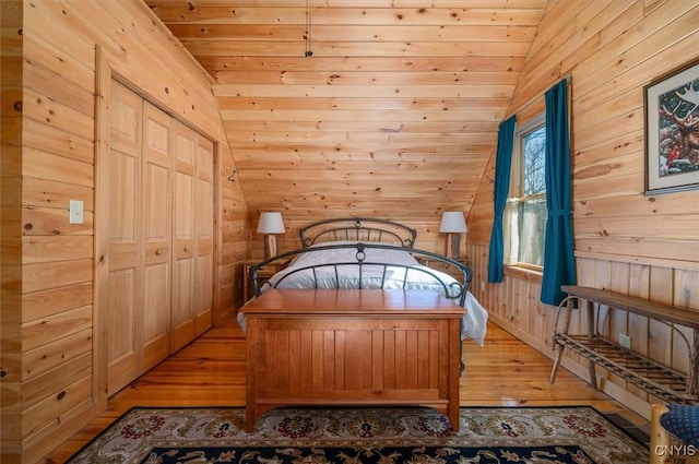 bedroom with wooden walls, lofted ceiling, wood ceiling, and light wood finished floors