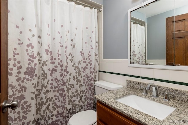 full bathroom featuring vanity, curtained shower, toilet, and tile walls