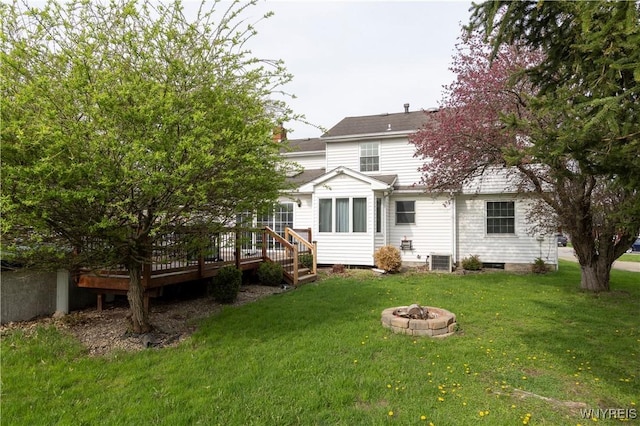 rear view of property with a lawn, a deck, a fire pit, and central air condition unit