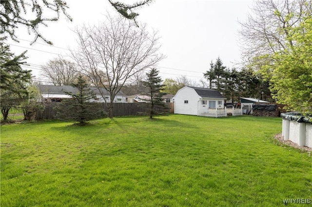 view of yard with fence and an outbuilding