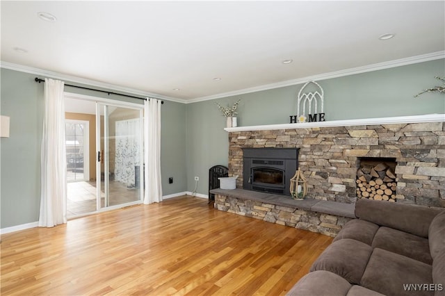 living area with baseboards, ornamental molding, a fireplace, and wood finished floors