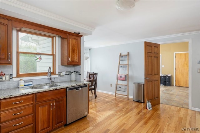 kitchen with stainless steel dishwasher, baseboards, a sink, light wood-style flooring, and backsplash