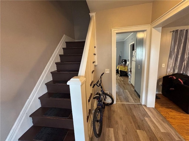 staircase with baseboards and wood finished floors